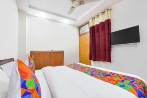 a bedroom with a white bed and a red curtain at Hotel Shyam Villa - Govindpuri Metro in New Delhi