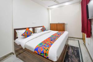 a bedroom with a large bed with a colorful blanket at Hotel Shyam Villa - Govindpuri Metro in New Delhi