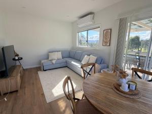 a living room with a blue couch and a table at Tangory Farmstay in Glendon Brook +36 photos