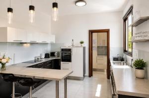 a kitchen with white appliances and a table in it at Palm Tree Villa By Staycom in Oroklini