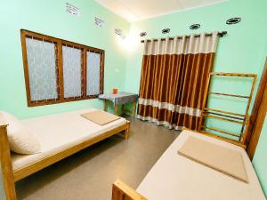 a small room with a bed and a window at Yarl Retreat - Jaffna Town - Non-AC in Jaffna