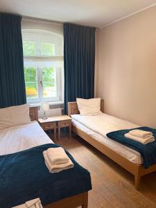 a room with two beds and a window at Kasztanowy Pałac in Swadzim