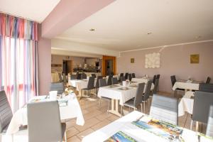 a dining room with white tables and chairs at Hotel garni Zwickau-Mosel in Mülsen