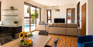 a living room with a table with a bowl of fruit at Palm Tree Villa By Staycom in Oroklini