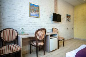 a room with three chairs and a desk and a tv at Art хостел-готель "Адреналін" in Lutsk