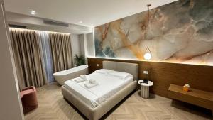 a bedroom with a bed and a bath tub and a painting at Moncler Residence in Ksamil +43 photos