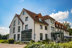 a large white building with a brown roof at Hotel garni Zwickau-Mosel in Mülsen