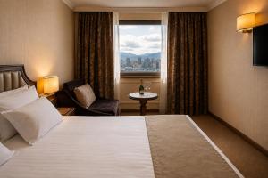 a hotel room with a bed and a window at Astoria Grand Hotel in Sofia +50 photos