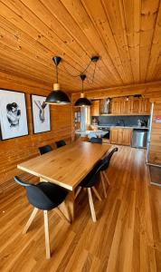 a wooden dining room table with chairs and a kitchen at Chalet O Refúgio 3 in Penhas da Saúde