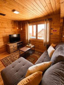 a living room with two couches and a television at Chalet O Refúgio 3 in Penhas da Saúde