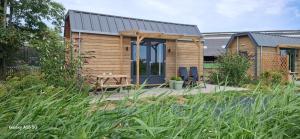 a small wooden house with a picnic table in a garden at Buorkerijhûske A - Tussen Wad en Weide in Hallum