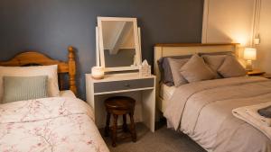 a bedroom with two beds and a mirror and a stool at Farm Lodge in Monaghan