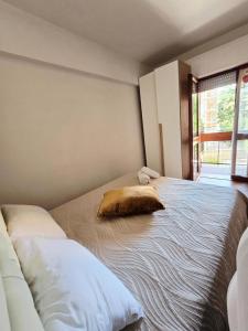 a bedroom with a large bed with a pillow on it at B&B ADU Civitavecchia in Civitavecchia