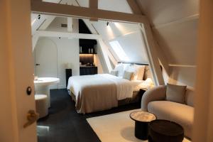 a bedroom with a bed and a chair in a room at Priorij Corsendonk in Oud-Turnhout