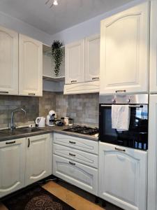a kitchen with white cabinets and a stove top oven at B&B ADU Civitavecchia in Civitavecchia