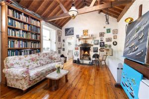a living room with a couch and a fireplace at Biddy's Cottage Dalkey in Dublin
