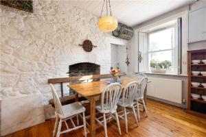 a dining room with a wooden table and chairs at Biddy's Cottage Dalkey in Dublin