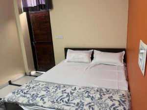a bed with two pillows on it in a room at Rao hotel in Jaipur