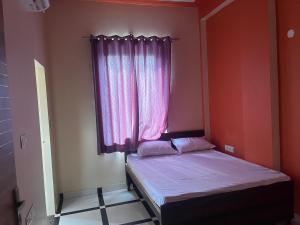 a small bedroom with a bed and a window at Rao hotel in Jaipur