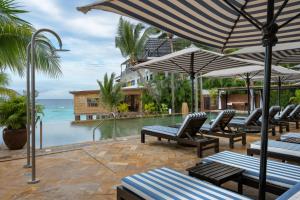Eine Gruppe von Stühlen und Sonnenschirmen neben einem Pool in der Unterkunft Z Hotel & Z2 Hotel in Nungwi