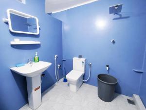 a blue bathroom with a toilet and a sink at Yarl Retreat Villa - Non-AC in Jaffna +11 photos