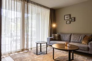 a living room with a couch and a table at Montafon Suites Schruns by ALPS RESORTS in Schruns