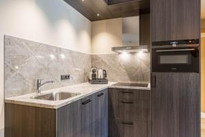 a kitchen with a sink and a stove at Montafon Suites Schruns by ALPS RESORTS in Schruns