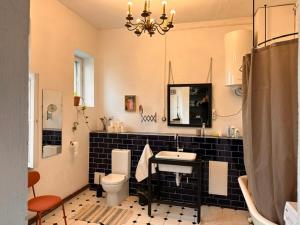 a bathroom with a sink and a toilet and a mirror at Room 0 in The White House Residence in Kuldīga