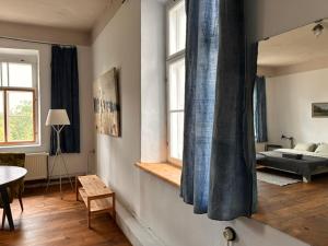 a living room with a bed and a mirror at Room 0 in The White House Residence in Kuldīga