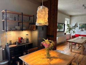 a vase of flowers on a wooden table in a kitchen at Room 0 in The White House Residence in Kuldīga