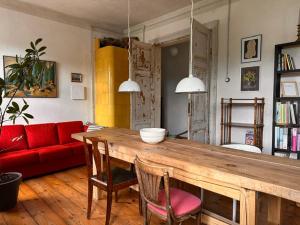 a living room with a wooden table and a red couch at Room 0 in The White House Residence in Kuldīga