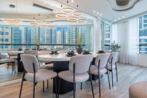 a dining room with a table and chairs and large windows at Vacationer Holiday Homes I Stunning 4 Bed I 10 Min from Marina Mall in Dubai