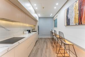 a kitchen with a counter and chairs in it at Vacationer Holiday Homes I Stunning 4 Bed I 10 Min from Marina Mall in Dubai