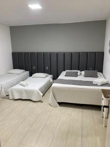 a bedroom with two beds and a wall at The Reds Pousada in Penha