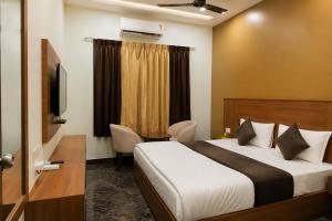 a hotel room with a bed and a television at Triveni Hotel And Restaurant in Barsāna