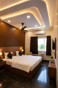a bedroom with a large bed with a ceiling at Triveni Hotel And Restaurant in Barsāna