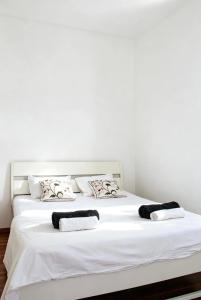 a large white bed with two pillows on it at Heritage Courtyard Apartment in Bruck an der Leitha