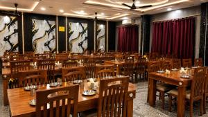 a dining room with wooden tables and chairs at Triveni Hotel And Restaurant in Barsāna