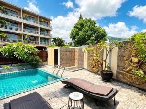 a swimming pool in front of a building at patong v hotel in Patong Beach
