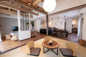 an open living room and dining room with a table and chairs at Villa Arco Miyakojima in Miyako-jima