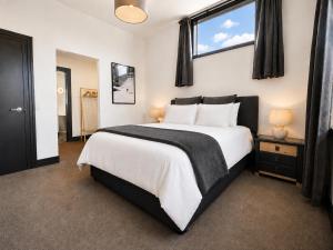 a bedroom with a large bed with a window at The Nelson Loft - Sauna, Balcony & City Centre Living in Nelson