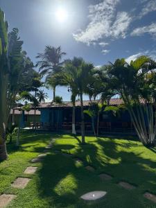 a resort with palm trees and a putting green at Pousada Maraí in Amontada