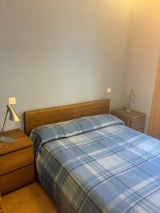 a bedroom with a bed with a blue plaid blanket at Plazacuervo in Pancorbo