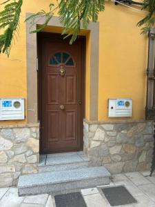 a brown door on a yellow building with stairs at Plazacuervo in Pancorbo