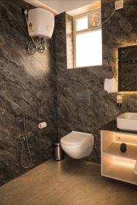 a bathroom with a toilet and a sink at DEO SIGNATURE SUITE Hotel in Rānchī +6 photos