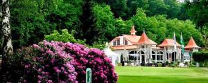 a large house with pink flowers in front of it at Traumhafte Lage am Kurpark in Bad Nauheim