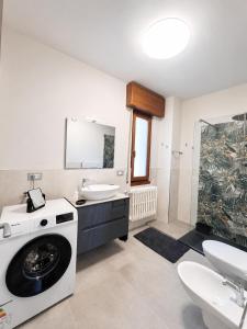 a bathroom with a washing machine and a sink at The Blue Sky Apartment with Lake view in Pianello Del Lario +16 photos