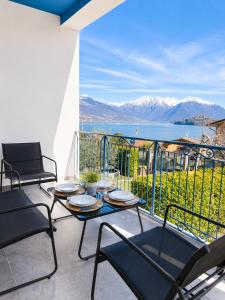 a patio with chairs and tables and a view of the water at The Blue Sky Apartment with Lake view in Pianello Del Lario