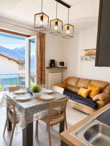 a kitchen and living room with a table and a couch at The Blue Sky Apartment with Lake view in Pianello Del Lario