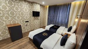 a hotel room with two beds and a television at Al Baron Hotel - فندق البارون in Al Mawşil
